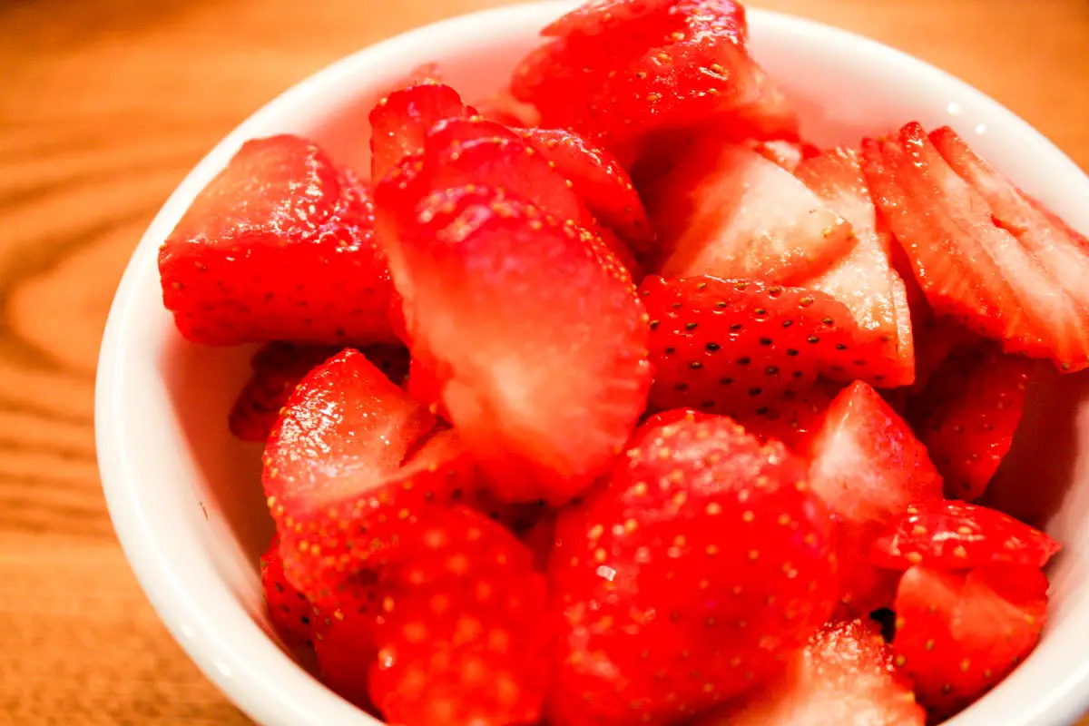 White bowl filled with sliced strawberries