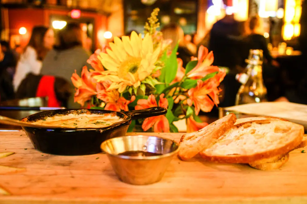 Skillet of melted Pecorino cheese plate with honey, crostini and pear slices