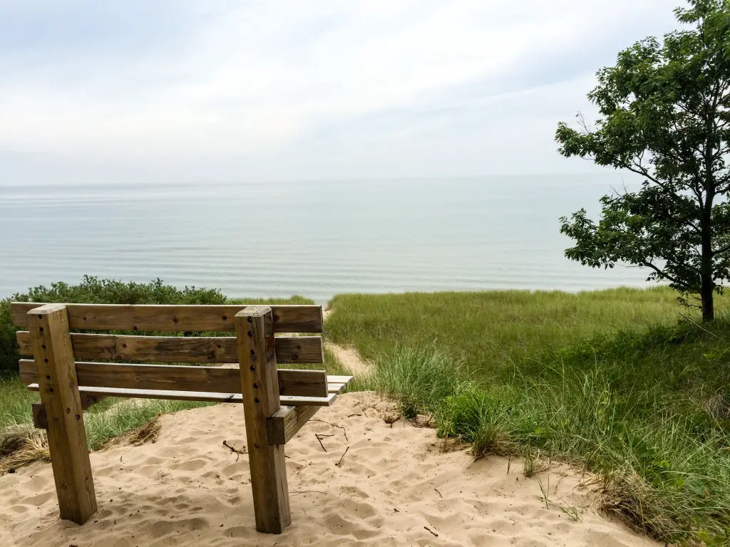 A bench atop a sand dune overlooks the Lake Michigan beach at Saugatuck Dunes State Park in Saugatuck, Michigan.