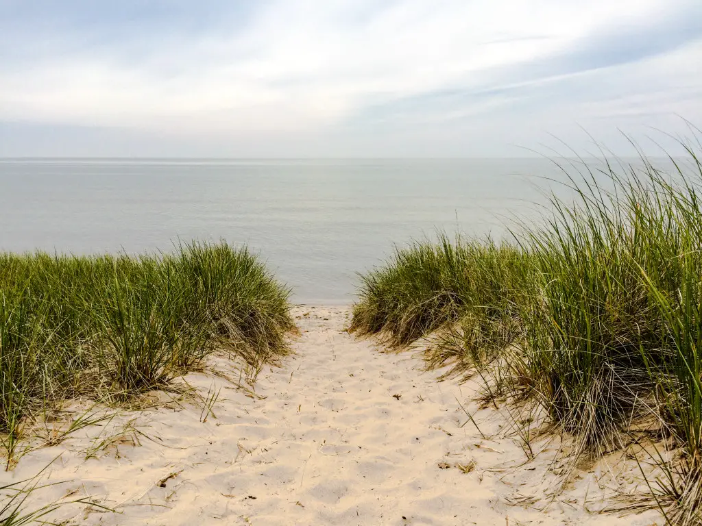 A small sand dune leads to Lake Michigan at Saugatuck Dunes State Park in Saugatuck, Michigan