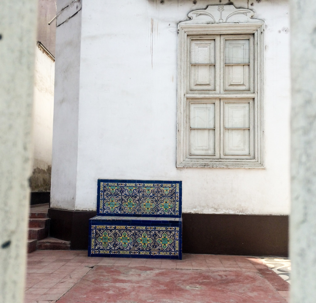 An ornately patterned bench sits outside a white building in Chosica, Peru. | The Epicurean Traveler