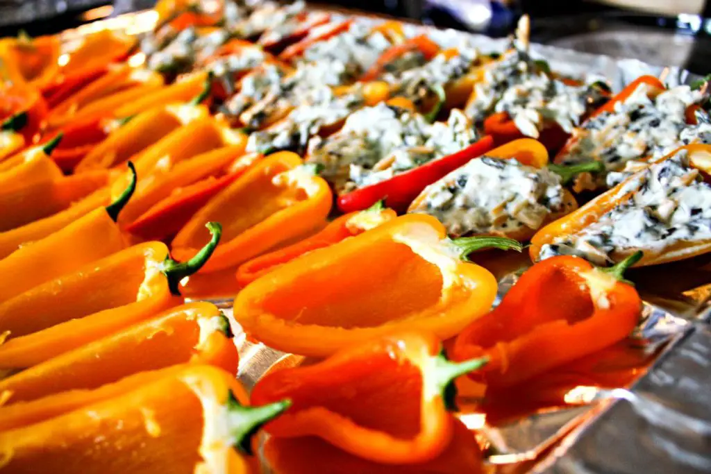 Mini sweet peppers getting stuffed and ready to bake