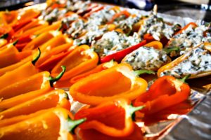 Mini sweet peppers getting stuffed and ready to bake