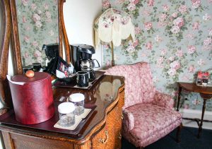 Hotel Boulderado historic guest room furnished with Victorian decor and modern coffee maker in Boulder, Colorado, USA
