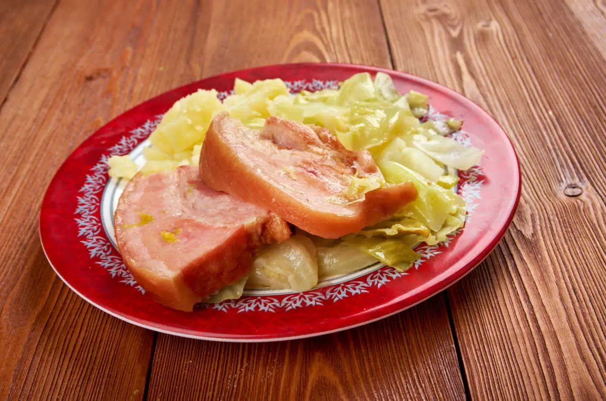 Irish bacon and cabbage dish on red plate