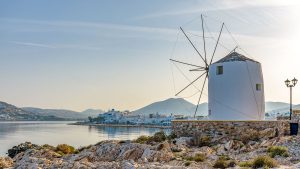 Panorama morning view of the Gulf of Parikia with a windmill and traditional whitewashed houses in the background on Paros island, Greece