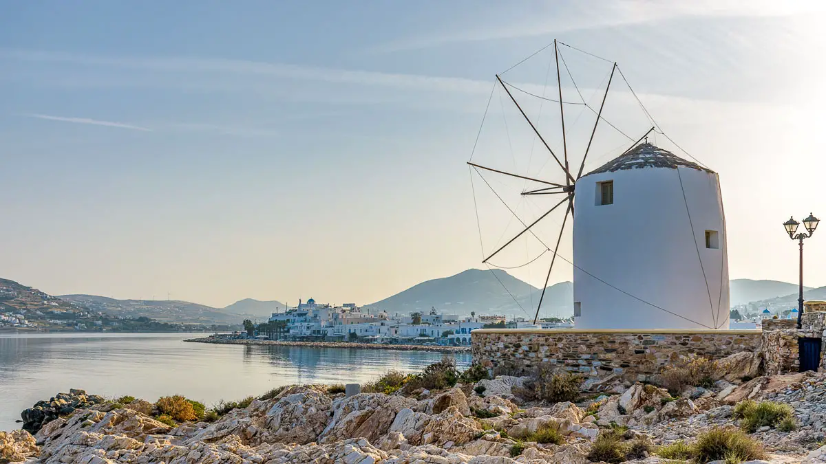 Panorama morning view of the Gulf of Parikia with a windmill and traditional whitewashed houses in the background on Paros island, Greece