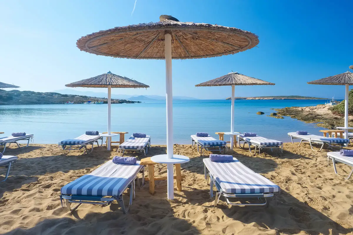 Umbrellas with sunbeds on beautiful sandy Santa Maria beach on Paros, Greece