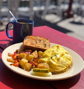 Casco Bay omelette, filled with Maine lobster and crab meat, with home fries and cinnamon raisin toast and a cup of hot coffee during breakfast at The Porthole in Portland, Maine, USA