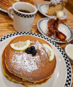 The Village Deli breakfast of lemon blueberry pancakes, bacon, and coffee cake in Bloomington, Indiana, USA