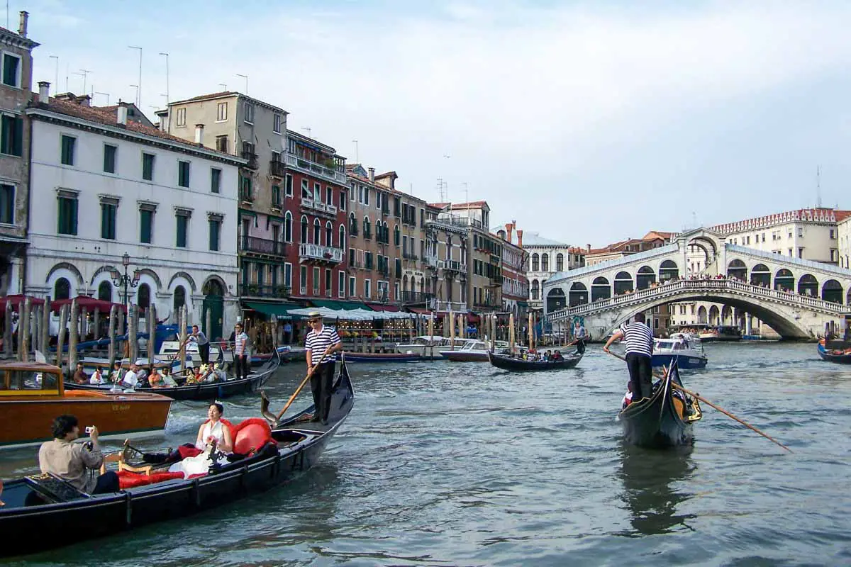 Gondolas and boats on the Grand Canal near the Rialto Bridge in Venice, Italy