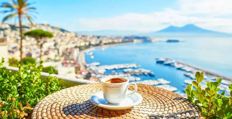 Cup of fresh espresso coffee in a cafe with a view of Mount Vesuvius in Naples, Campania, Southern Italy