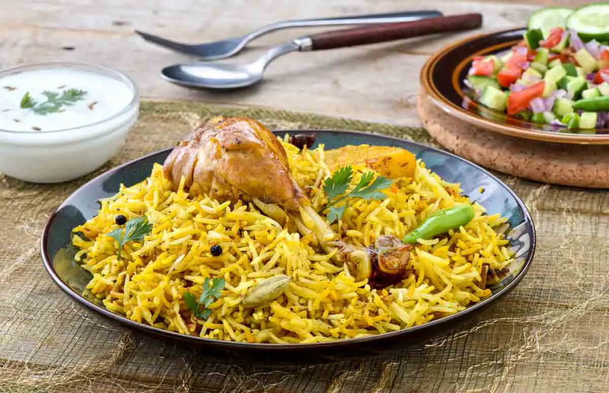 Pakistani Chicken Biryani with yogurt and salad in background