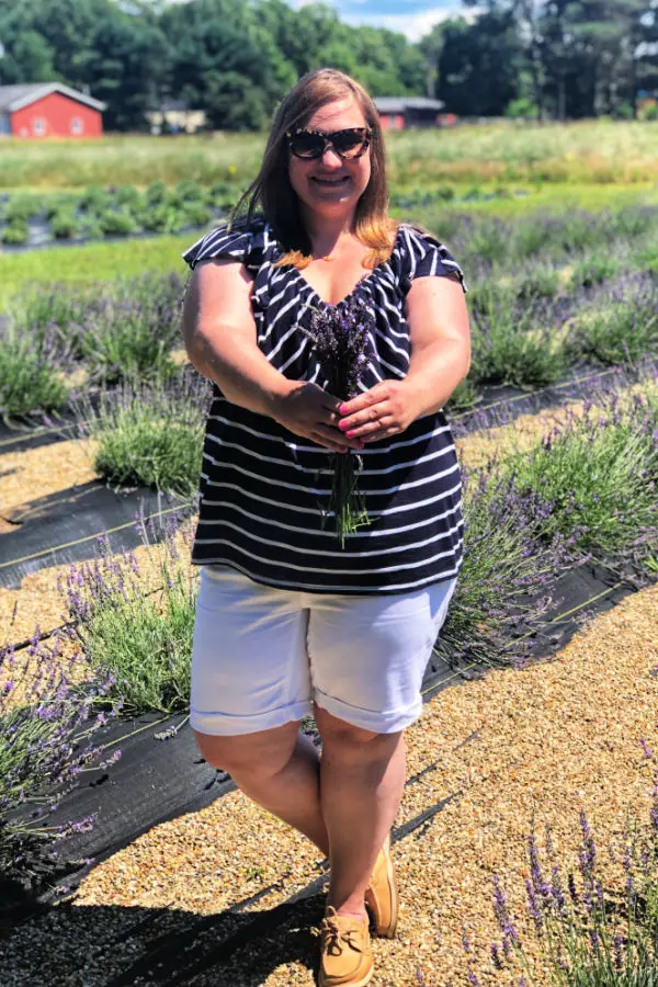 Woman holds lavender bouquet in lavender field