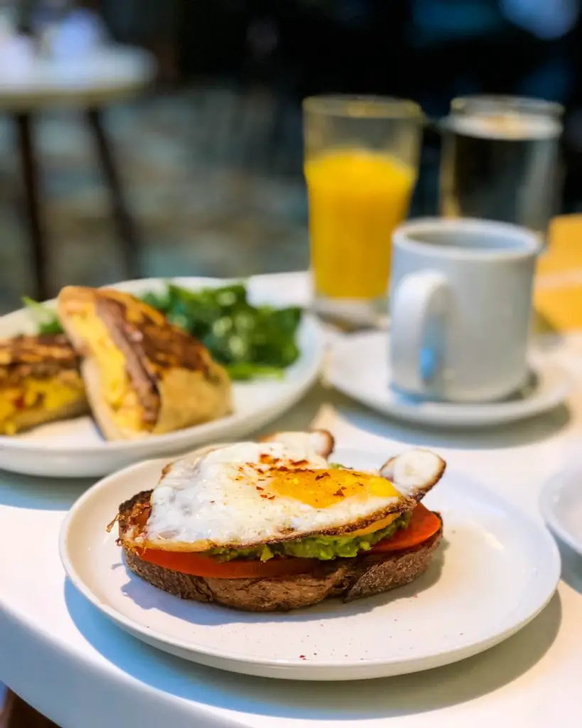 Breakfast of avocado toast and a breakfast burrito with coffee and orange juice at Sava's in Ann Arbor, Michigan, USA