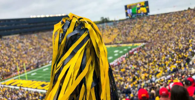 Maize-and-blue pompom is raised into the air during a Michigan football game at Michigan Stadium in Ann Arbor, Michigan, USA