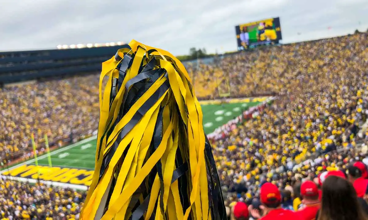 Maize-and-blue pompom is raised into the air during a Michigan football game at Michigan Stadium in Ann Arbor, Michigan, USA