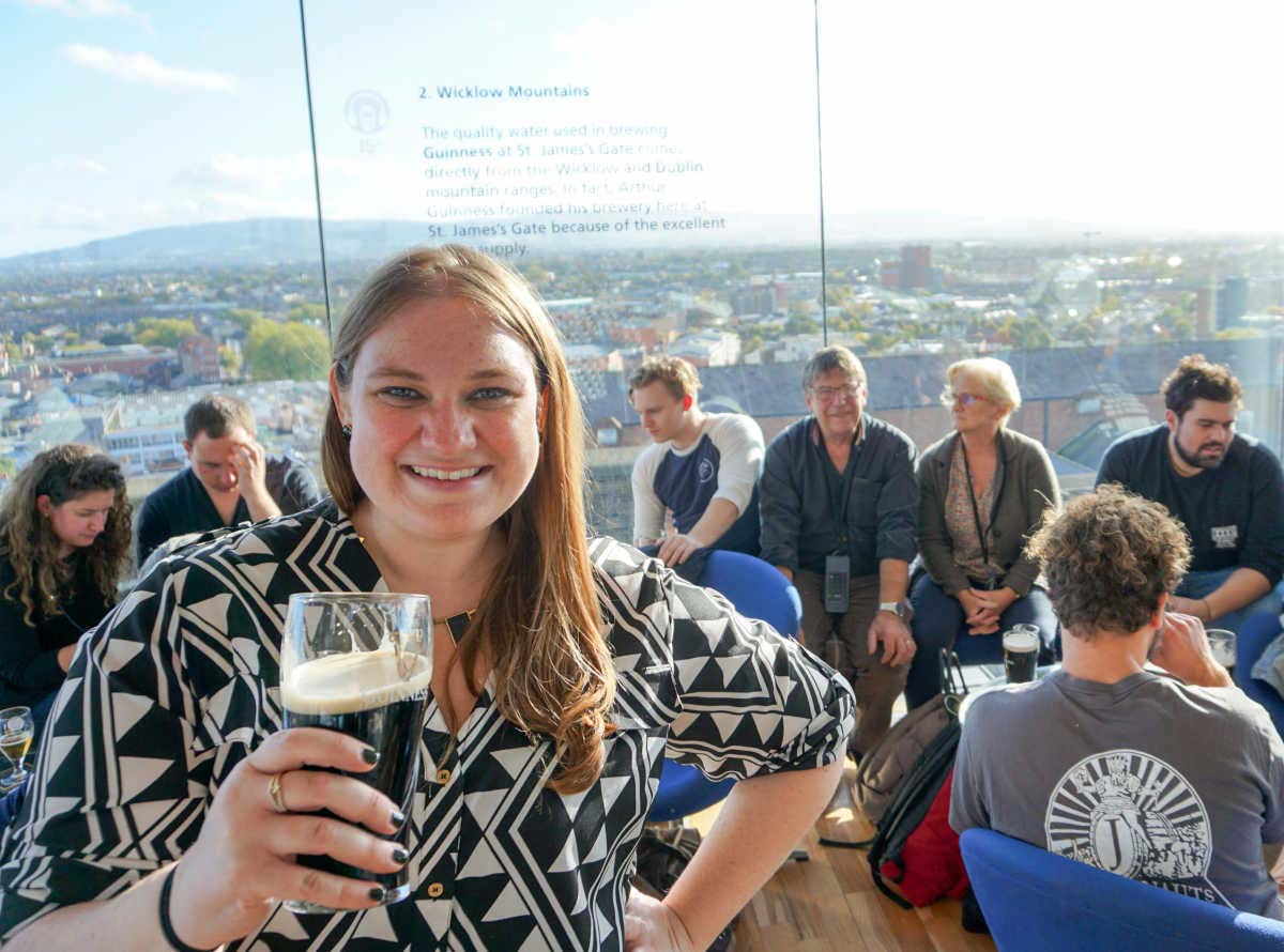 Travel blogger Erin Klema holds a pint of Guinness at the Guinness Storehouse in Dublin, Ireland