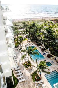 View of pools, beach, and ocean from Grand Beach Hotel Surfside guest room balcony
