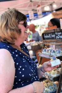 Shopper buying goat's milk soap at Bloomington Community Farmers' Market