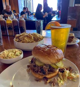 Pulled pork sandwich, coleslaw, waffle fries, carrot cake, and Bell's Oberon at Slows Bar BQ in Detroit, Michigan, USA