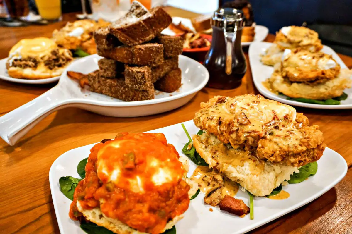 Duo of Eggs Benedict called "The Peacemaker" at Ruby Slipper Cafe in Orange Beach, Alabama, features fluffy Southern buttermilk biscuits rather than English muffins as the base layer.