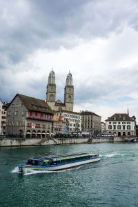 Limmat River boat cruises past Old Town Zurich and Grossmuenster cathedral