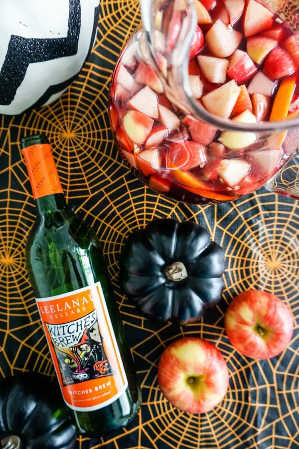 Leelanau Cellars Witches Brew wine bottle with Honeycrisp apples and sangria in Halloween setting