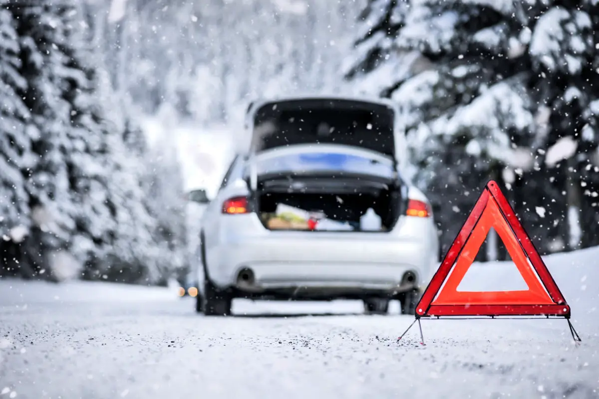 Car trinagle on highway with broken car in winter.