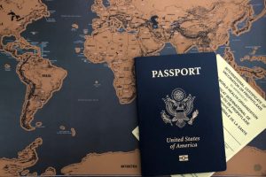 United States passport with vaccination booklet and world map background