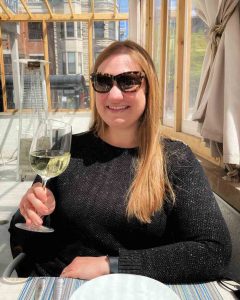 Woman holds glass of Greek white wine at Avli River North in Chicago, Illinois, USA
