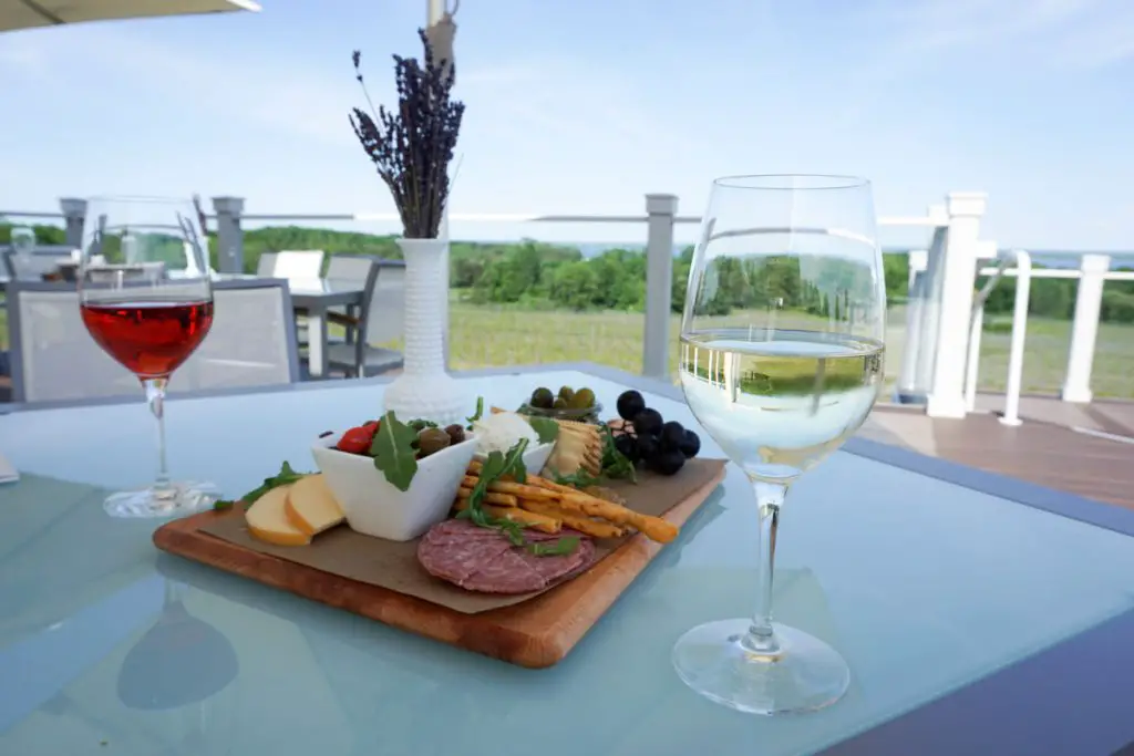 Glasses of Rosé and Dry Riesling white wine with a charcuterie board and vase of freshly picked lavender on the upper deck of Brys Estate Vineyard & Winery on Old Mission Peninsula, Traverse City, Michigan