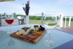 Glasses of Rosé and Dry Riesling white wine with a charcuterie board and vase of freshly picked lavender on the upper deck of Brys Estate Vineyard & Winery on Old Mission Peninsula, Traverse City, Michigan