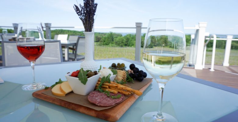 Glasses of Rosé and Dry Riesling white wine with a charcuterie board and vase of freshly picked lavender on the upper deck of Brys Estate Vineyard & Winery on Old Mission Peninsula, Traverse City, Michigan