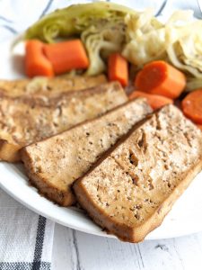 Vegan "corned beef" tofu with carrots and cabbage in white setting