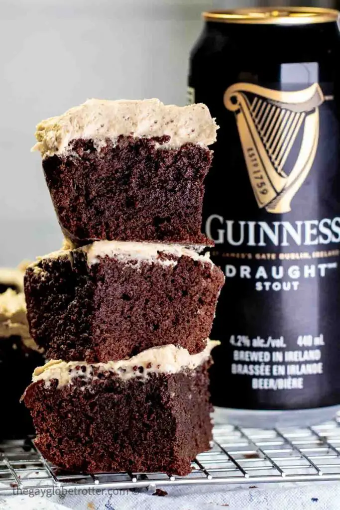 Stack of three Guinness brownies with espresso Guinness buttercream on cooling rack next to Guinness beer can 