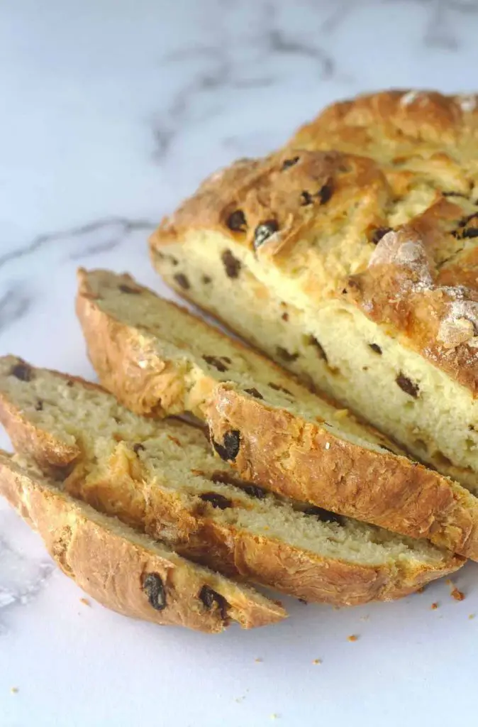 Sliced Irish soda bread loaf on white-and-gray granite countertop
