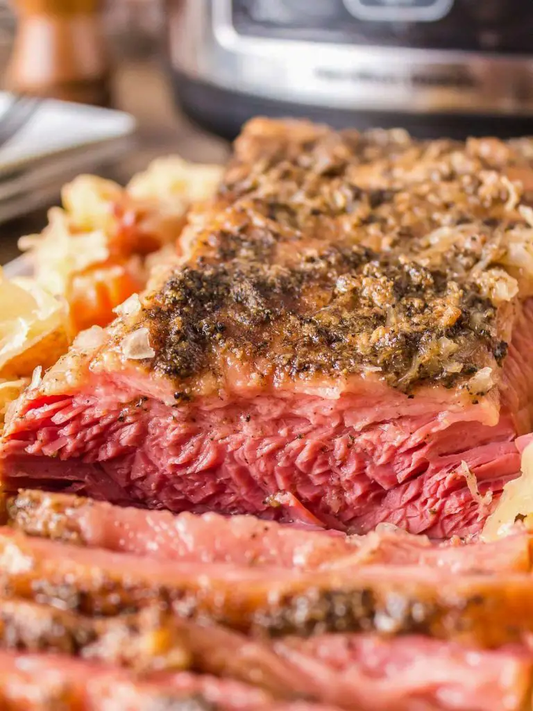 Sliced corned beef with sauerkraut and slow cooker in background