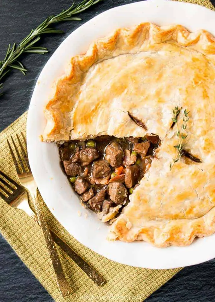 Steak, mushroom and stout pie with a slice missing to show pie filling