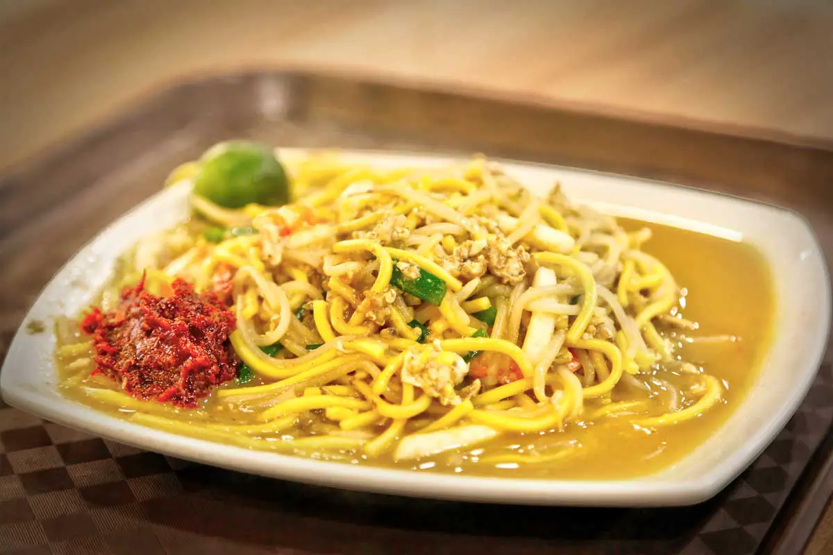 A plate of Hokkien mee, one of the best street foods to eat in Singapore, on a brown tray 