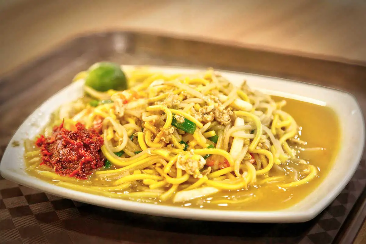 A plate of Hokkien mee, one of the best street foods to eat in Singapore, on a brown tray