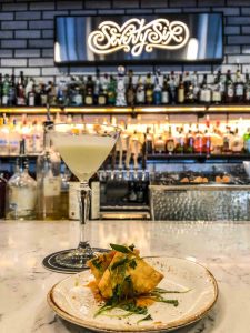 Craft cocktail and lobster rangoon on the bar of Seventy-Six in Holland, Michigan
