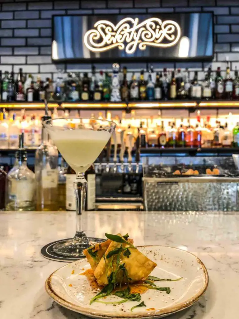 Craft cocktail and lobster rangoon on the bar of Seventy-Six in Holland, Michigan