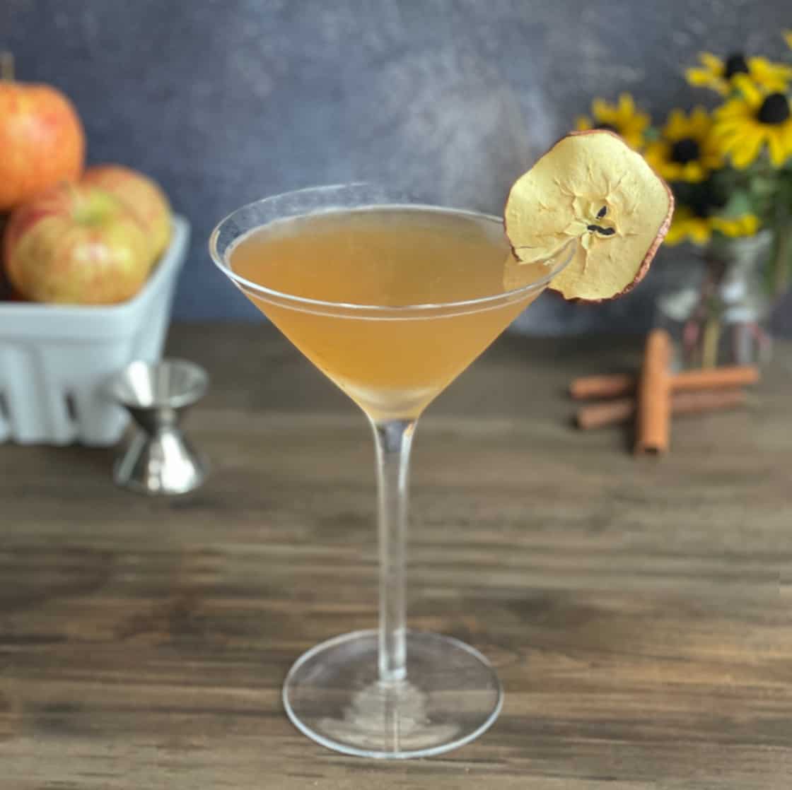Apple cider martini in a martini glass with apple chip garnish