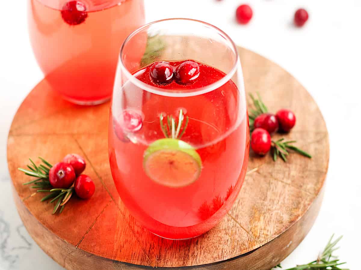 Holiday Cranberry Prosecco Cocktail on a wooden serving board with cranberry garnishes