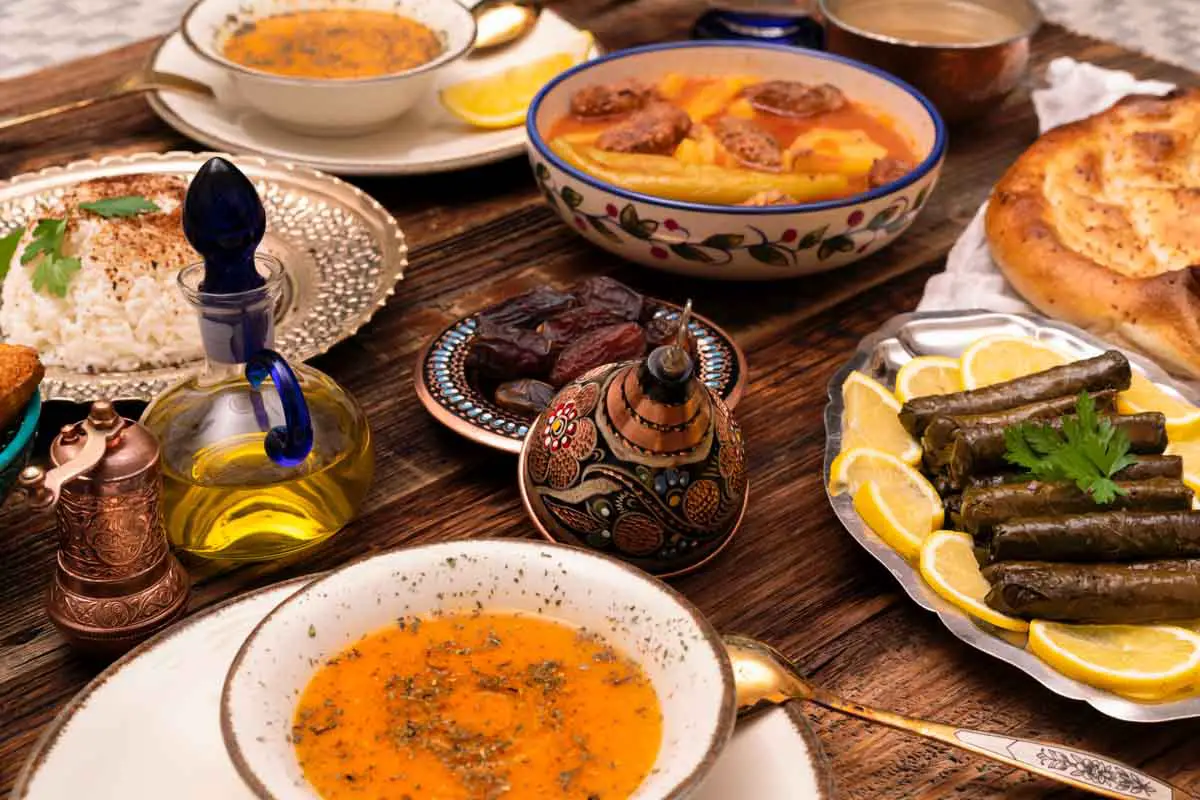 Traditional Turkish iftar meal during Ramazan with dates, pilaf, Izmir meatballs with potatoes, red lentil soup, dolmas, Ramazan pidesi, and other dishes