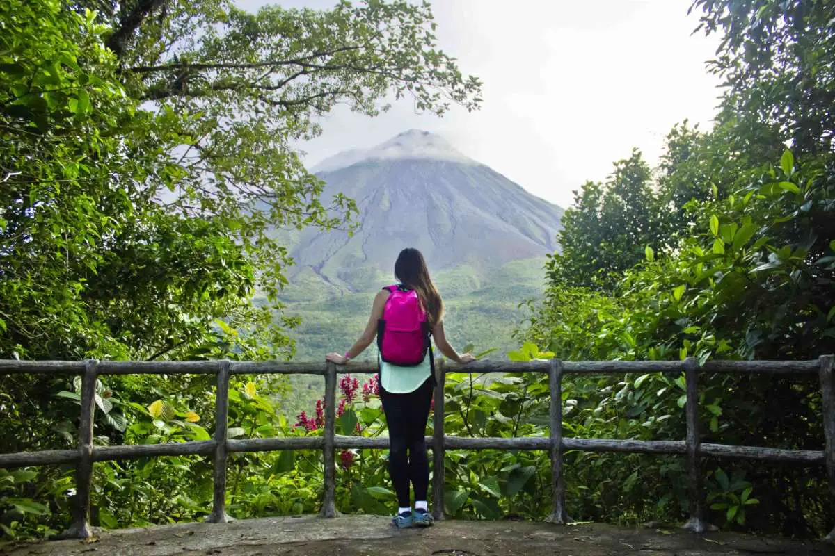 Female hiker looks out at Arenal Volcano in Costa Rica