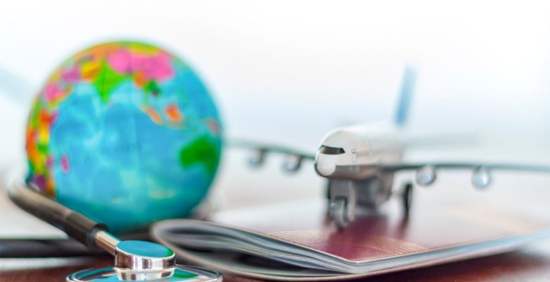 Travel health with globe, stethoscope, passport, and model airplane