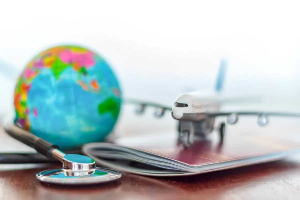 Travel health with globe, stethoscope, passport, and model airplane