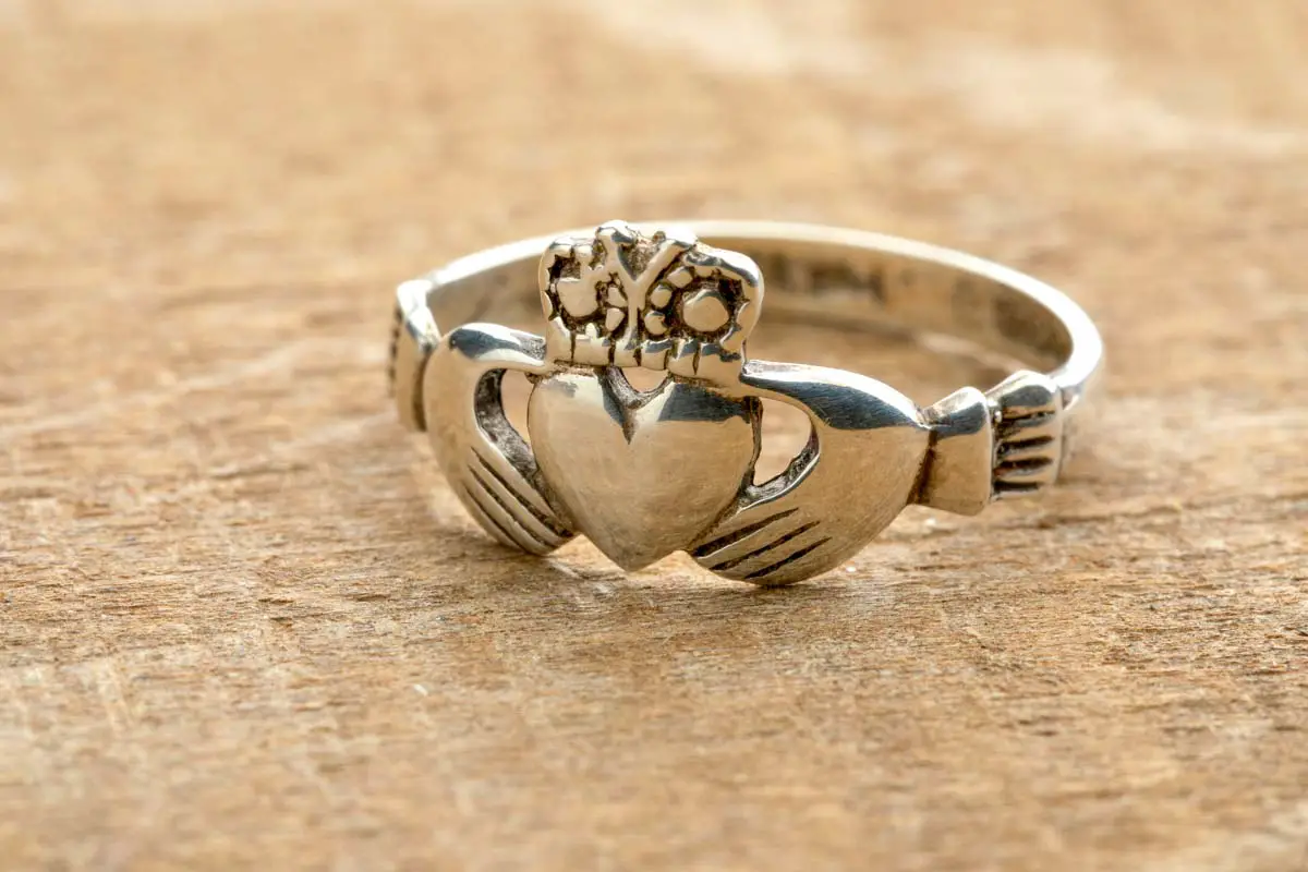 Silver Irish Claddagh ring on wooden background